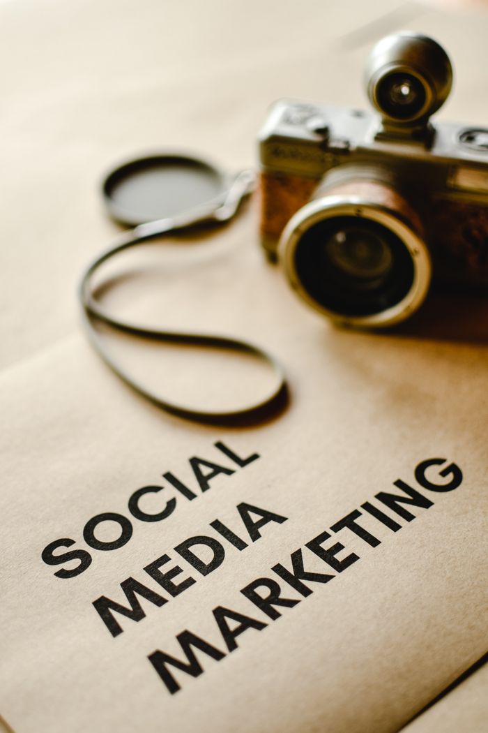 Services Close-up of a vintage camera on brown paper labeled with 'Social Media Marketing'.